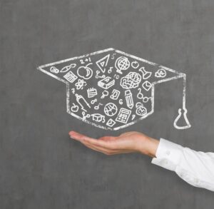 a hand holding a graduation hat